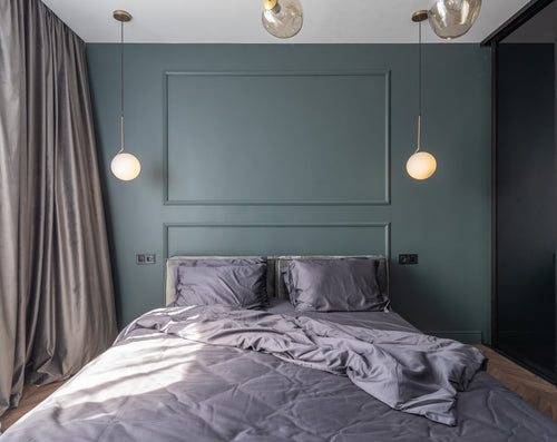 Neatly made bed with soft grey linen