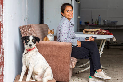 Smiling woman at home with her dog and ginger cat